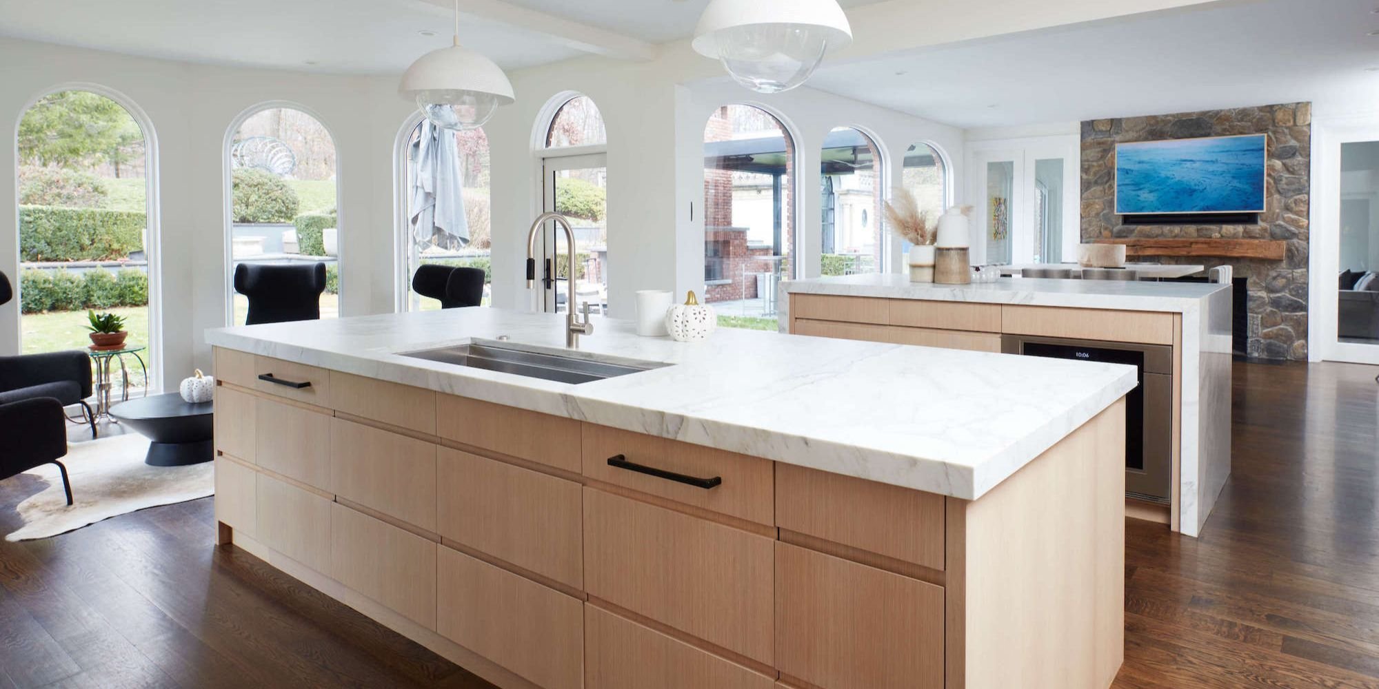 Kitchen remodel with large windows, two islands, and a dining area by TR Design-Build in New Canaan