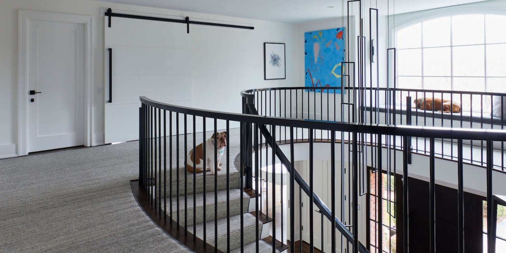 Image of a remodeled stairwell, rustic sliding door, and bench window seat by TR Design Build in New Canaan, CT