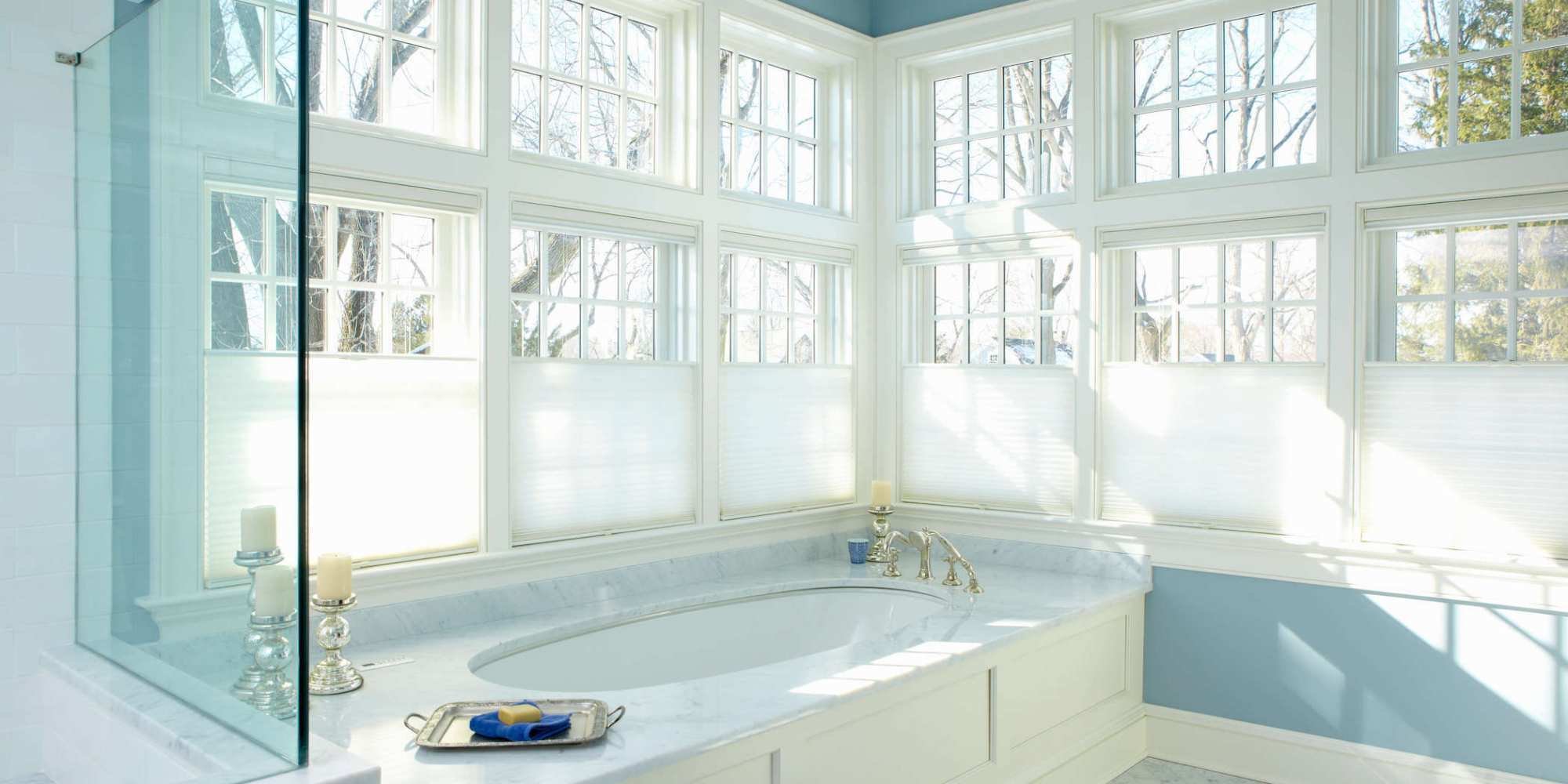 An airy primary bathroom addition in New Canaan by TR Design-Build featuring large windows and a soaking tub