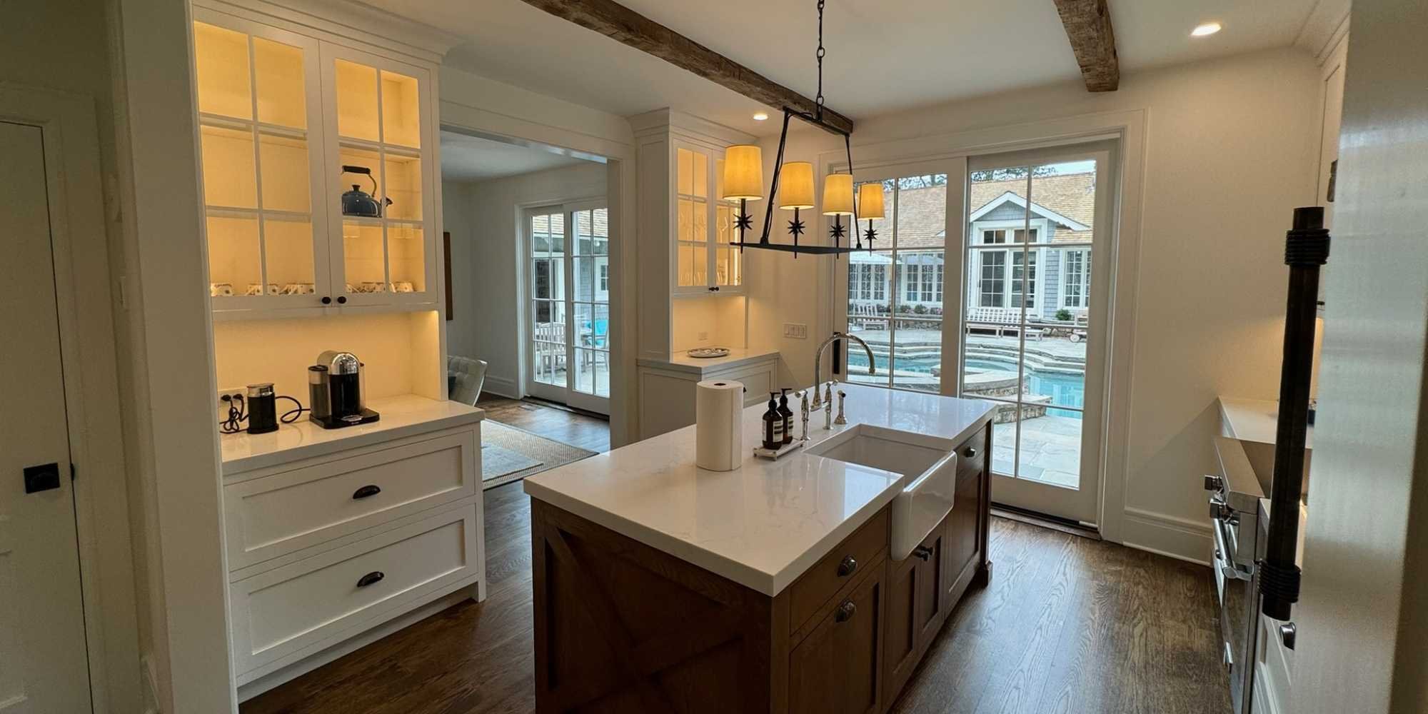 Kitchen with custom cabinets and outdoor pool access in New Canaan, CT by TR Design Build
