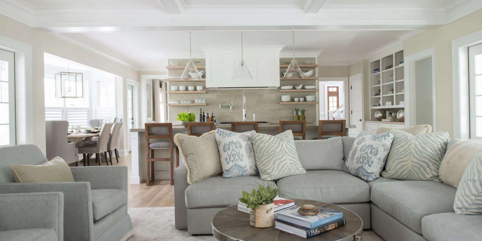 Bright open-plan living room with kitchen island and bar seating by TR Design Build