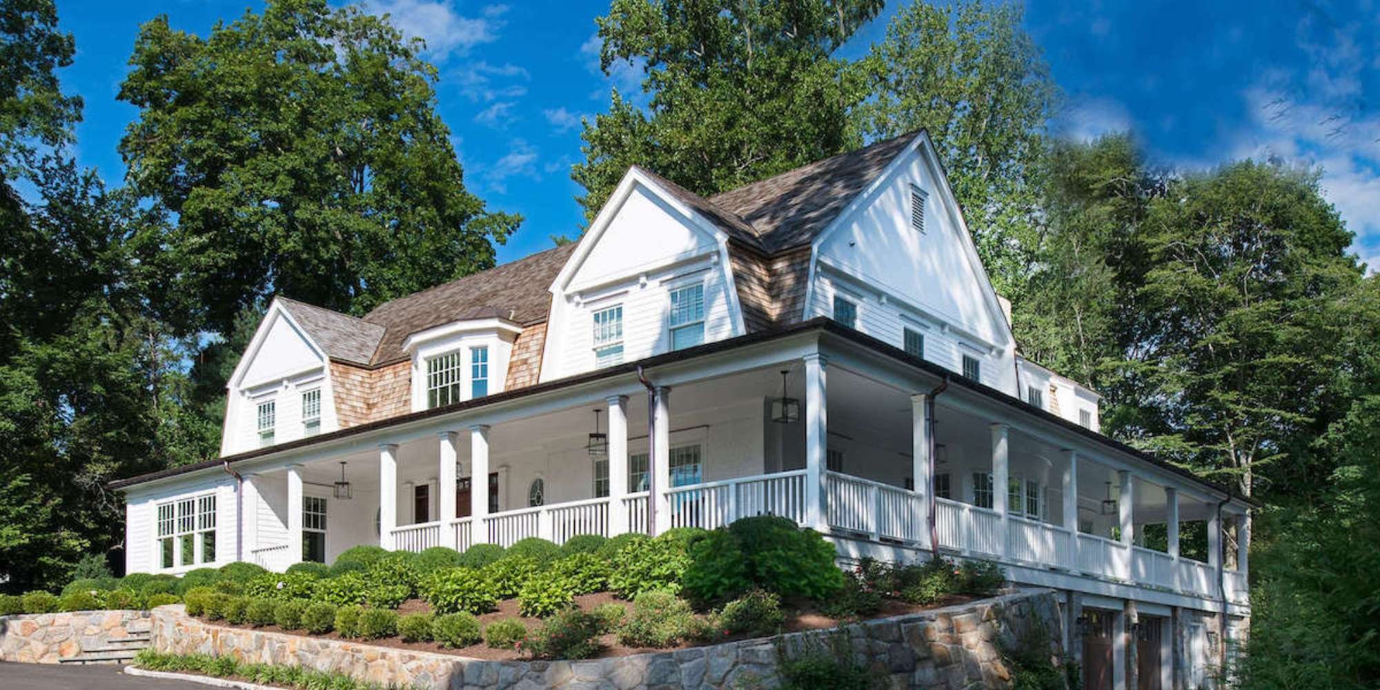 White two-story custom home with wood shake accents and detailed trim work in New Canaan