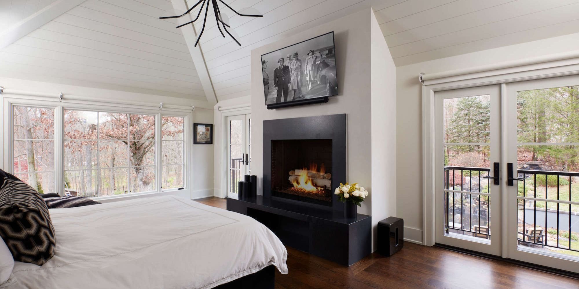 Bedroom with fireplace and TV in a New Canaan accessory structure by TR Design Build