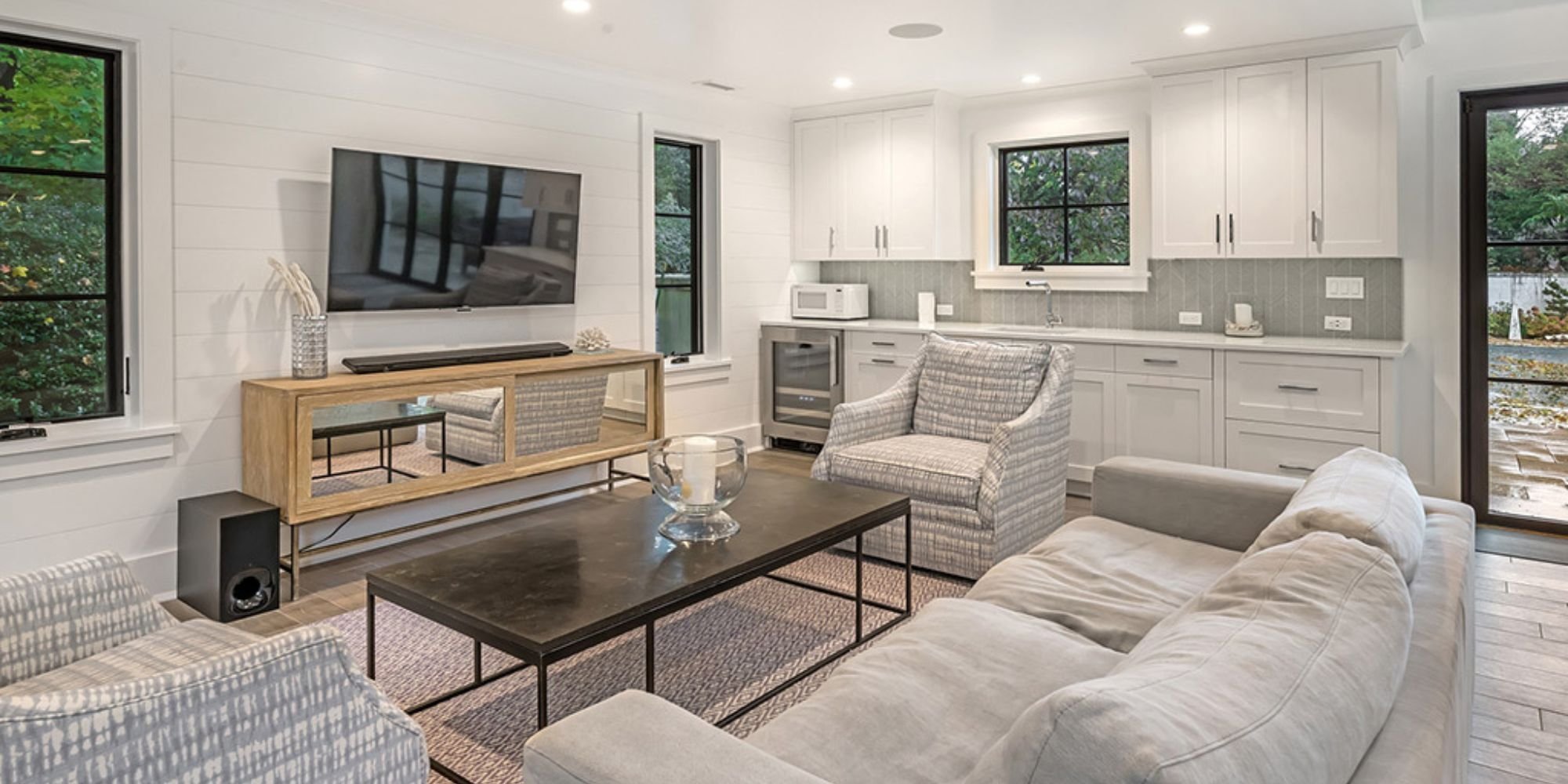 Bright home addition with white cabinetry, modern wet bar, and cozy seating area by TR Design Build in New Canaan, CT