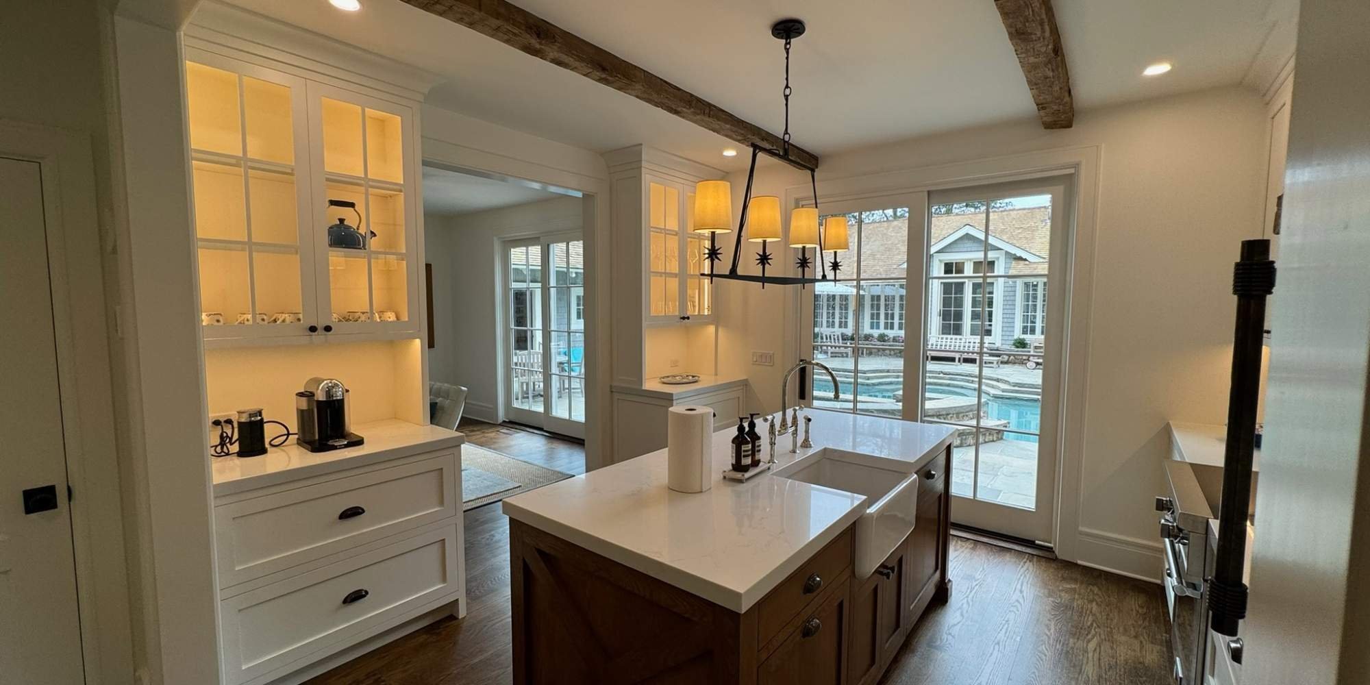 Bright New Canaan kitchen with custom cabinetry and pendant lighting by TR Design Build