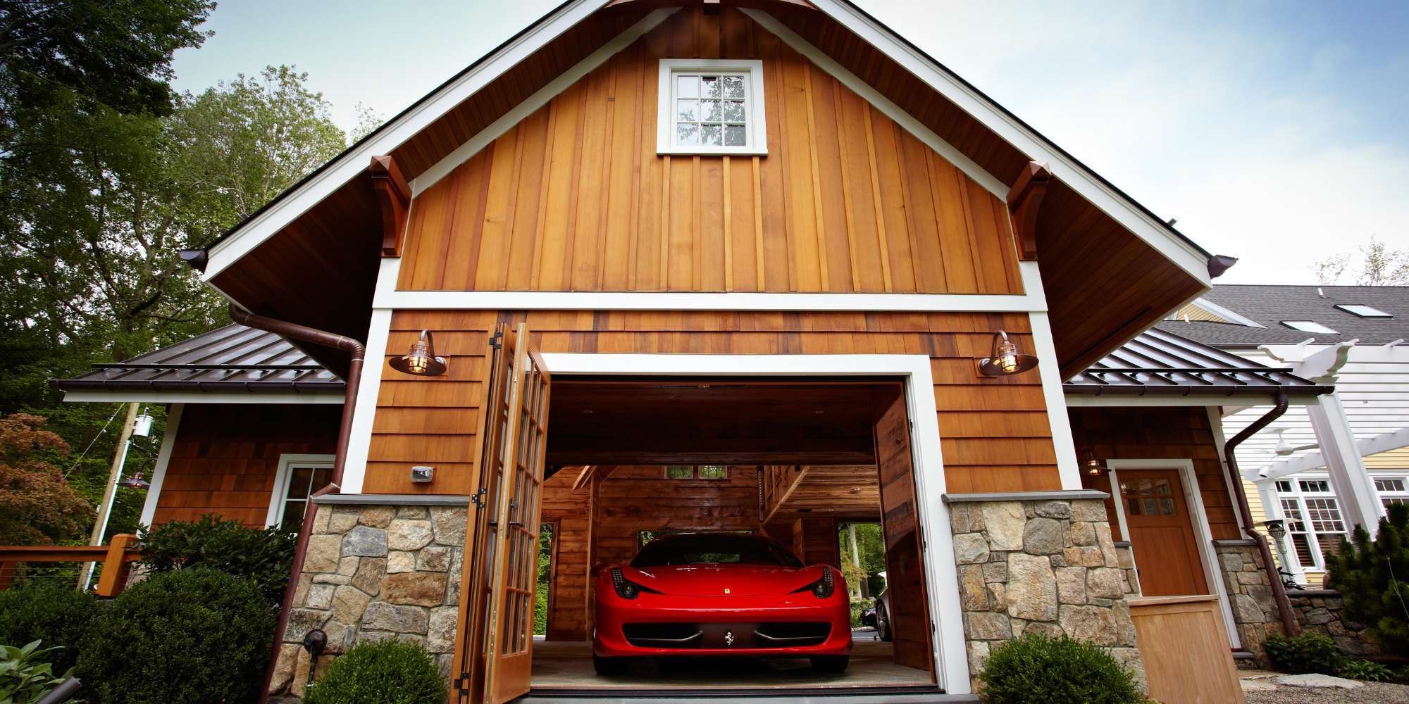 Custom garage in New Canaan with wood siding and stone accents by TR Design Build