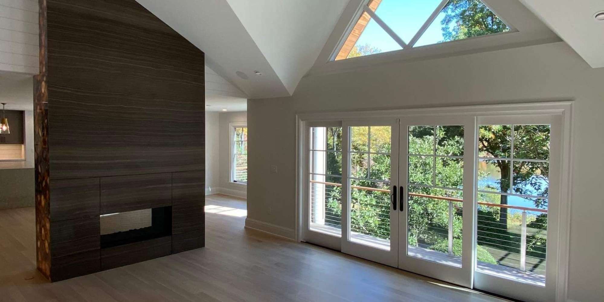 Living space addition featuring tall windows and fireplace by TR Design Build, New Canaan, CT