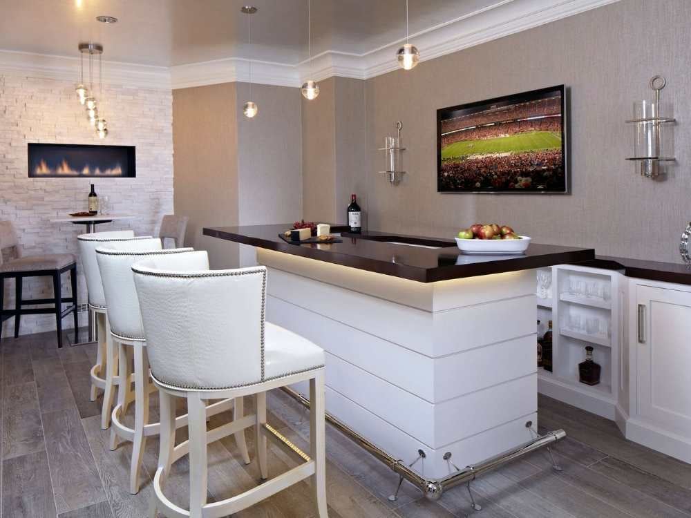 A custom bar area with seating and accent lighting under the counter by TR Design-Build A custom bar area with seating and accent lighting under the counter by TR Design-Build