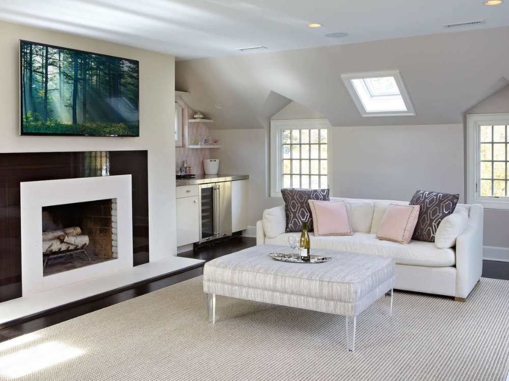 A living room remodel in a whole home remodel with a fireplace, large windows, and a skylight by TR Design-Build