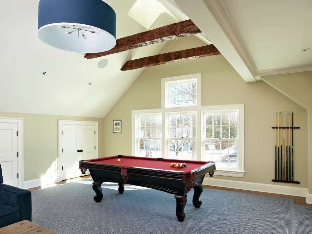 A recreation space home addition featuring a pool table and exposed beams by TR Design-Build in Fairfield, CT