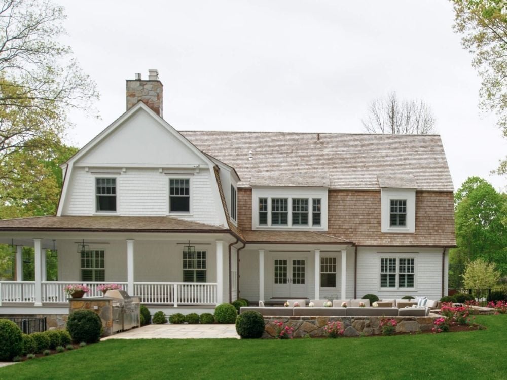 A custom home with a covered porch and and uncovered patio by TR Design-Build in Stamford, CT