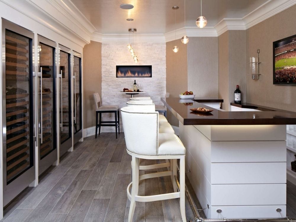 Basement remodel featuring a bar and four custom wine refrigerators by TR Design-Build