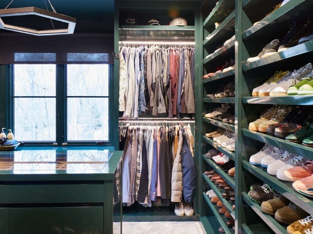 Custom walk-in closet with dedicated shoe storage, an island with drawers, and windows by TR Design-Build