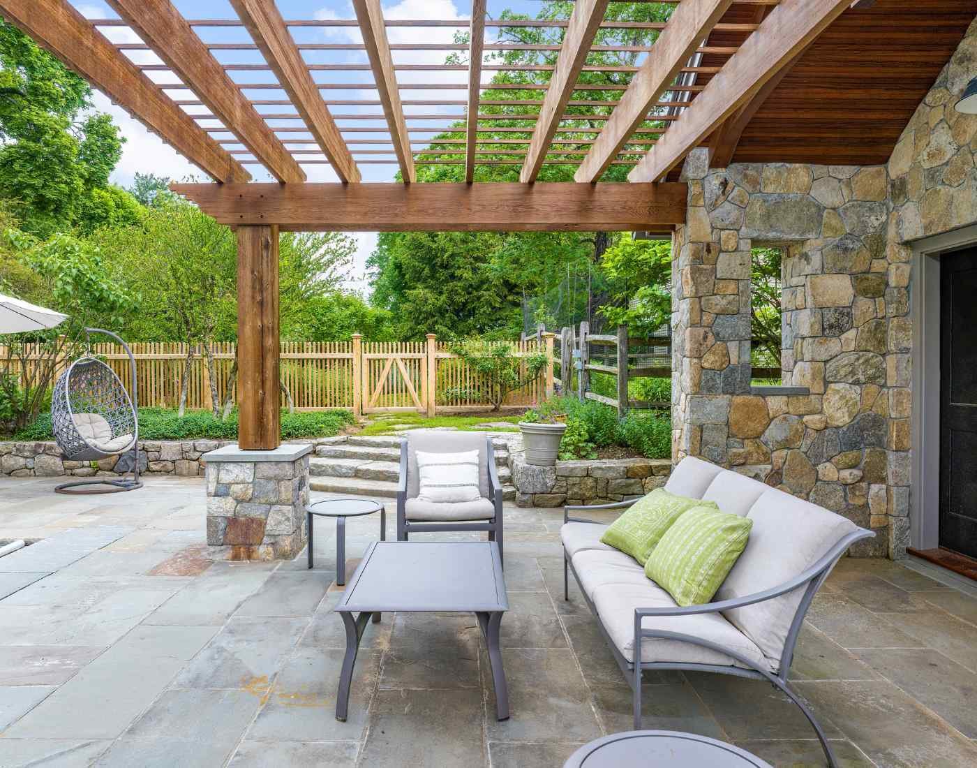 Image of an accessory structure patio with wood pergola and stone features by TR Design Build