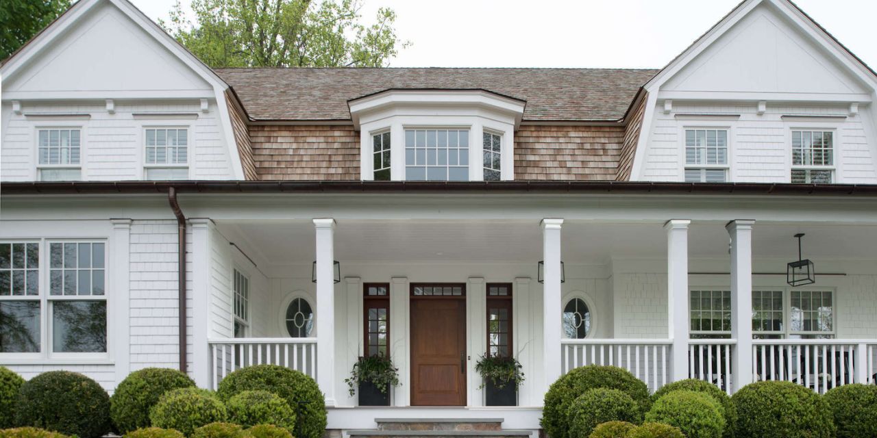 Elegant white colonial-style custom home with wood door and symmetrical windows in New Canaan