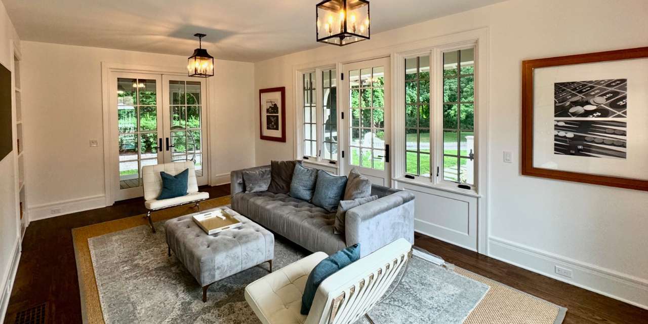 Bright living room with large windows, modern seating, and natural light by TR Design Build in New Canaan, CT