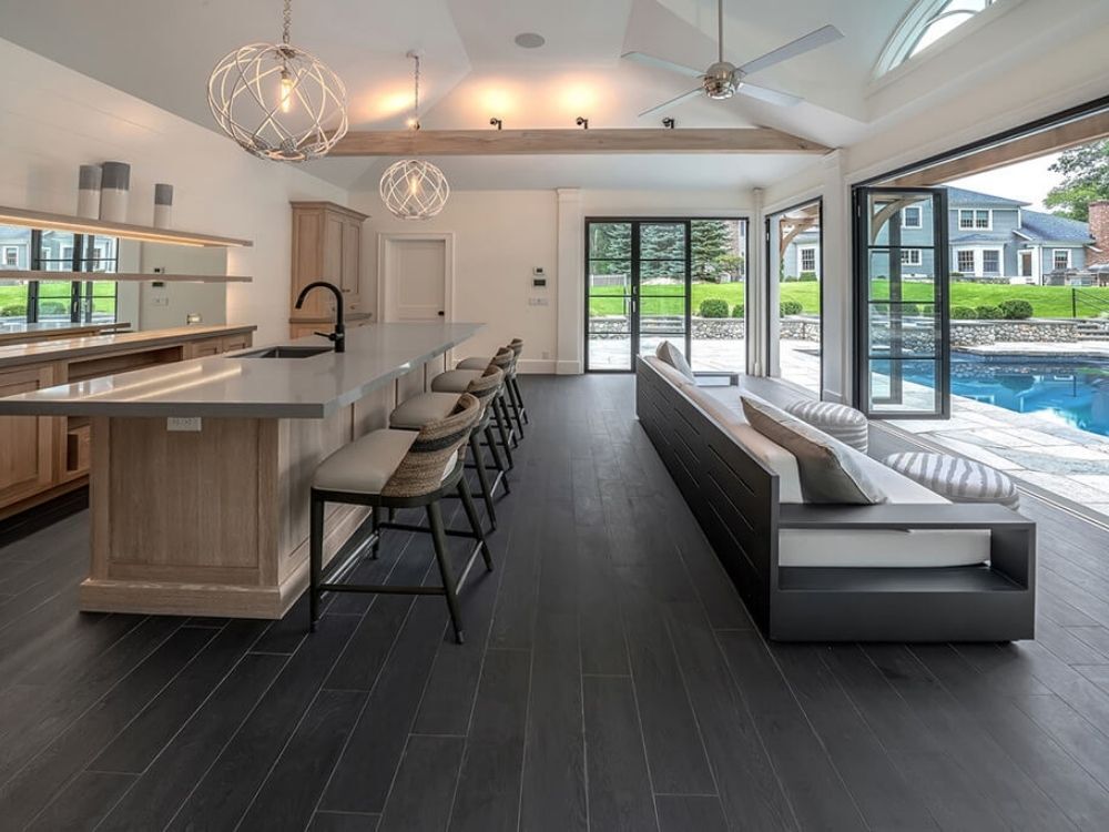 Interior of a pool house with a kitchen and lounge area in Stamford, CT by TR Design-Build