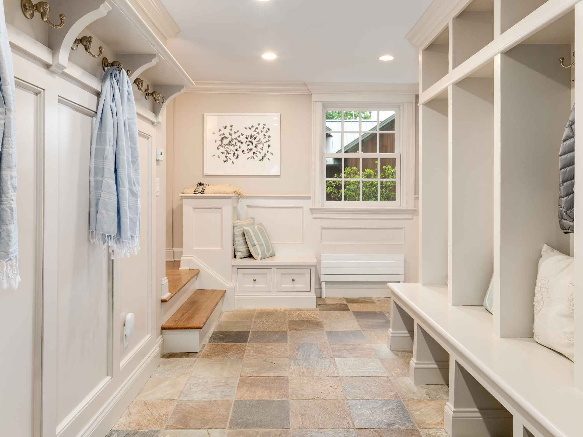 A remodeled mudroom with tile flooring, custom cabinetry, and open cubbies with hooks by TR Design-Build in New Canaan, CT A remodeled mudroom with tile flooring, custom cabinetry, and open cubbies with hooks by TR Design-Build in New Canaan, CT