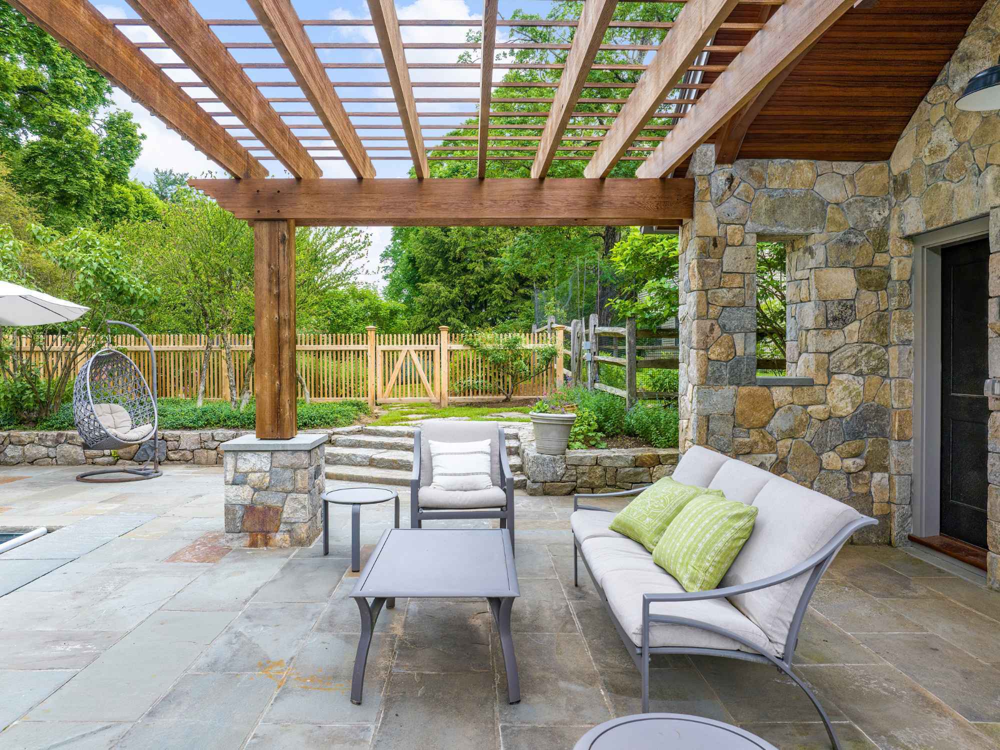 Poolside sitting area under a wood pergola by TR Design-Build in New Canaan, CT Poolside sitting area under a wood pergola by TR Design-Build in New Canaan, CT