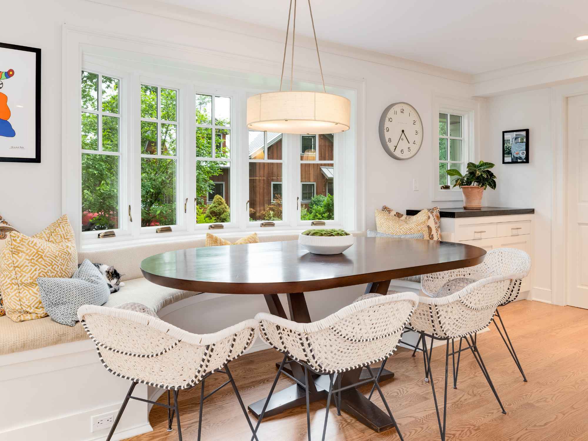 Remodeled dining room with a bay window, custom banquette, and oval dining table by TR Design-Build in New Canaan, CT Remodeled dining room with a bay window, custom banquette, and oval dining table by TR Design-Build in New Canaan, CT